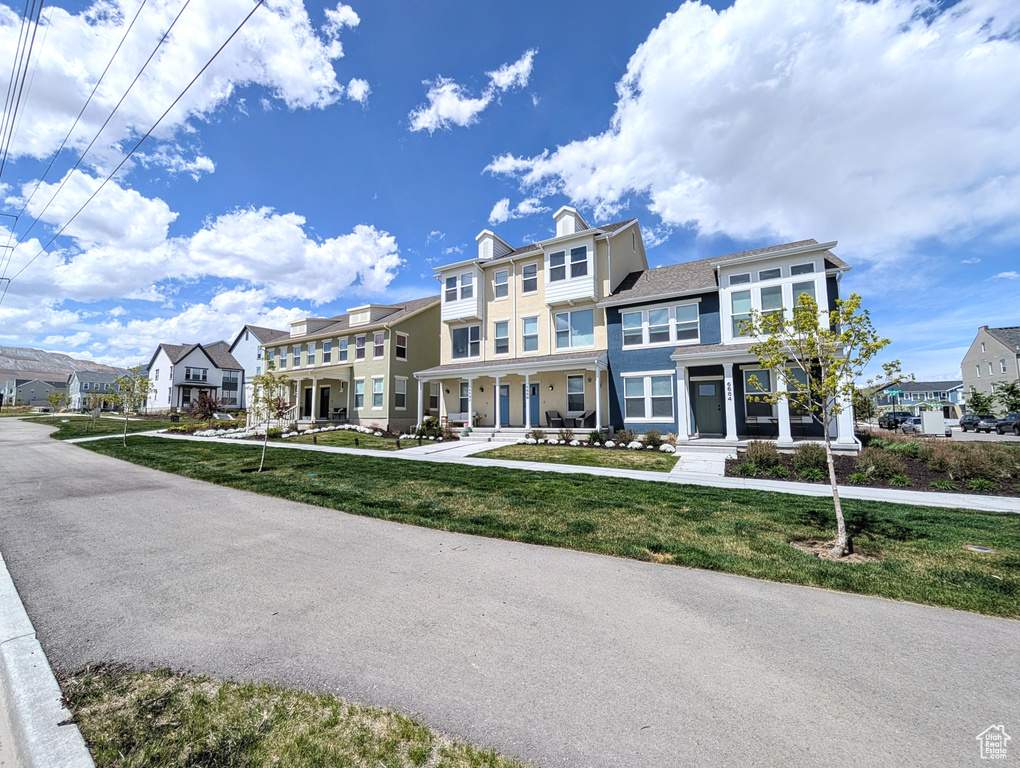 View of front of house featuring a chimney, a residential view, and a front lawn