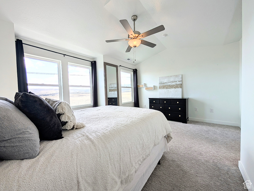 Carpeted bedroom featuring baseboards, ceiling fan, lofted ceiling, and visible vents