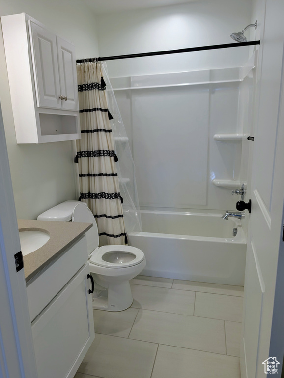 Bathroom with toilet, tile patterned flooring, shower / bath combo, and vanity