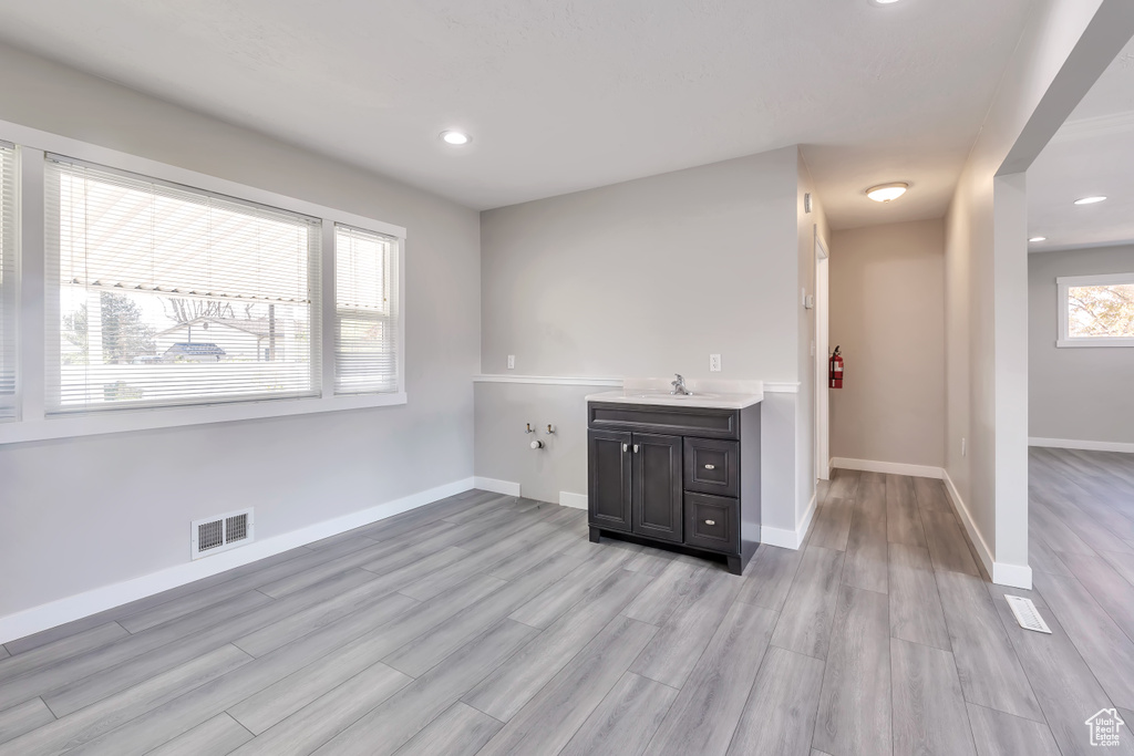 Bar featuring visible vents, a sink, baseboards, recessed lighting, and light wood-style flooring