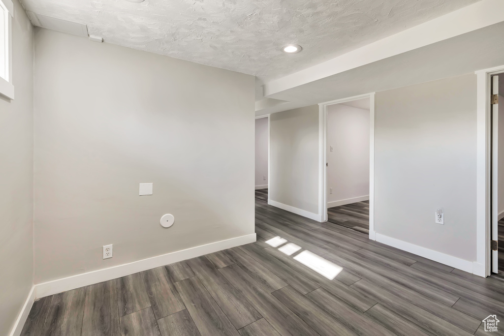 Spare room with baseboards, recessed lighting, a textured ceiling, and wood finished floors