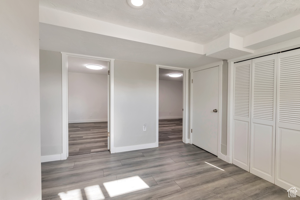 Unfurnished bedroom with a closet, baseboards, and wood finished floors