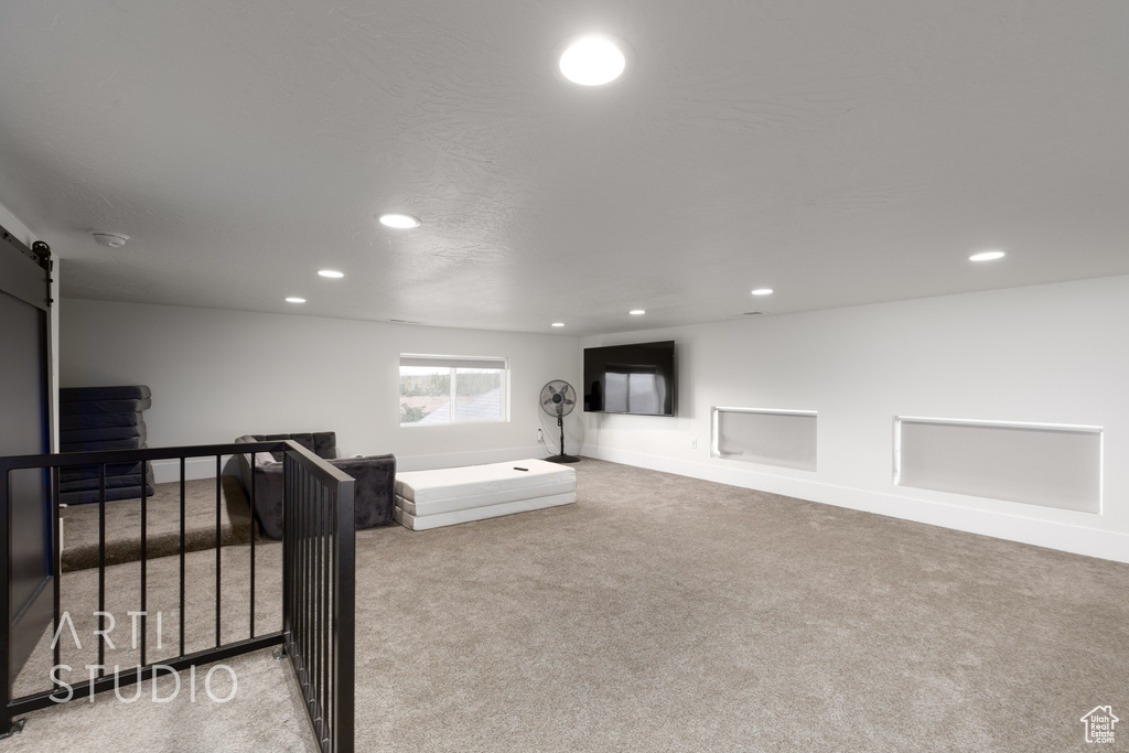 Exercise area featuring carpet floors, baseboards, recessed lighting, and a barn door