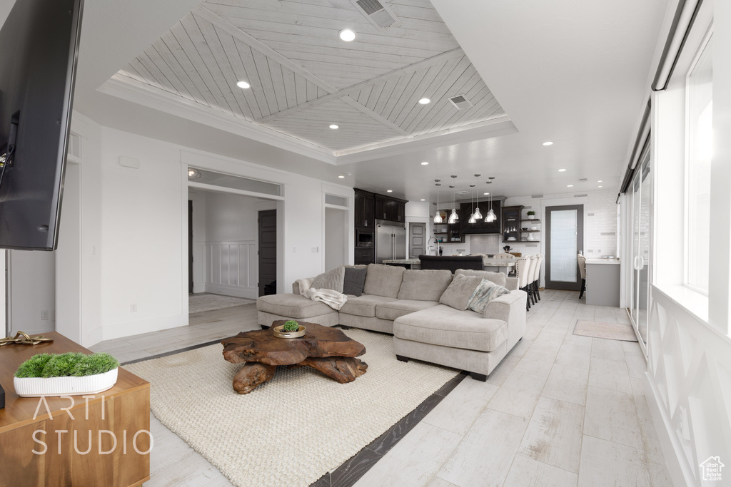 Living area featuring recessed lighting, visible vents, light wood finished floors, and a raised ceiling