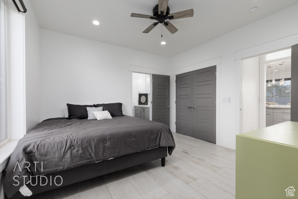 Bedroom with recessed lighting, ceiling fan, ensuite bathroom, and light wood finished floors