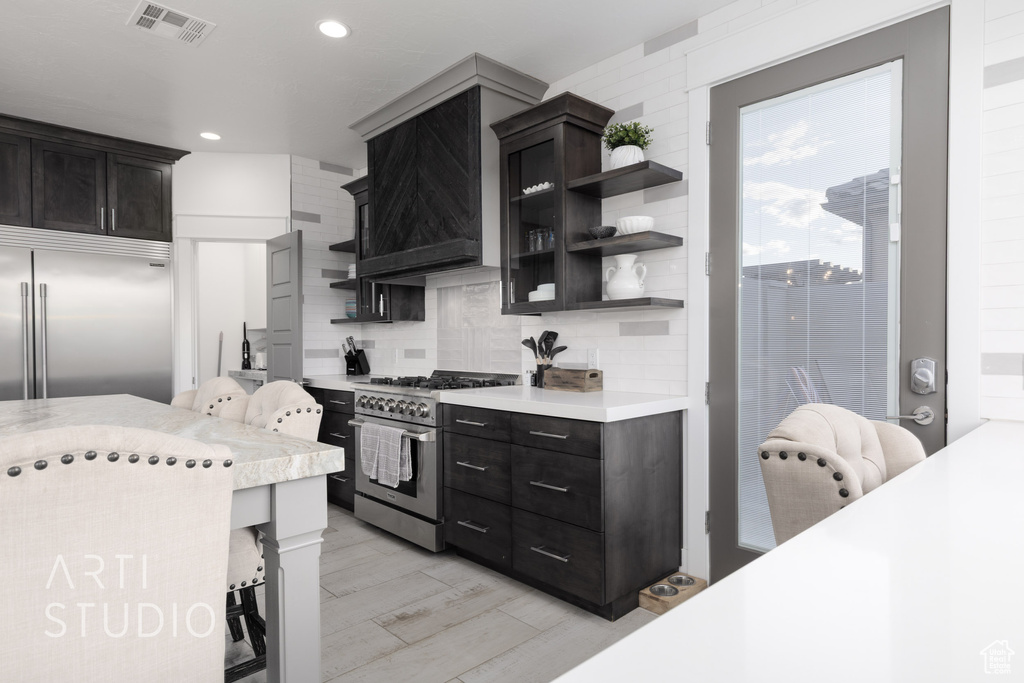 Kitchen featuring visible vents, open shelves, light countertops, and high quality appliances