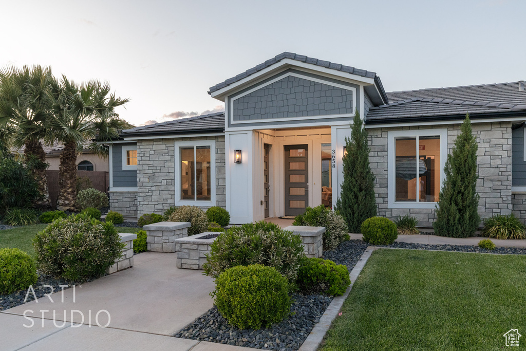 View of front of home featuring a front yard and stone siding