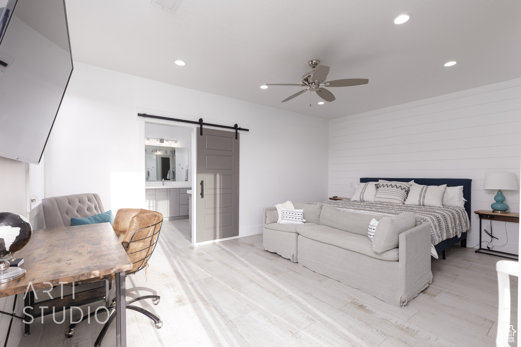 Bedroom featuring recessed lighting, a barn door, light wood-style flooring, and ensuite bathroom