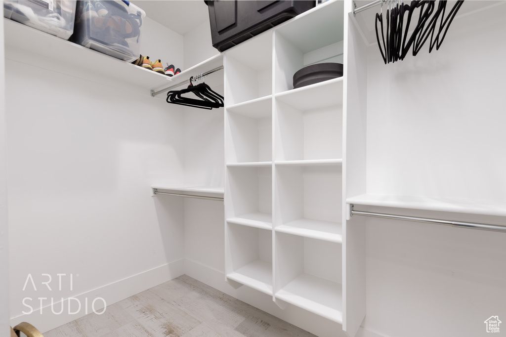 Walk in closet with wood finished floors