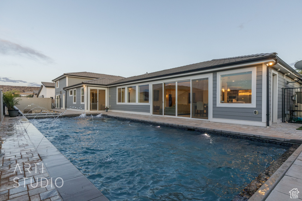 Rear view of house with a fenced in pool, a patio area, and fence