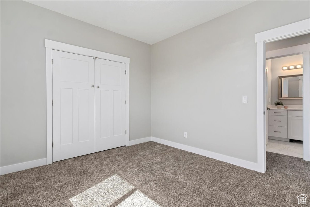 Unfurnished bedroom featuring baseboards, carpet flooring, and a closet