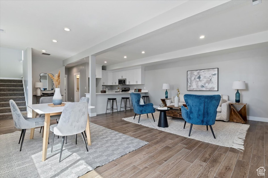 Dining space with visible vents, stairs, wood finished floors, baseboards, and recessed lighting