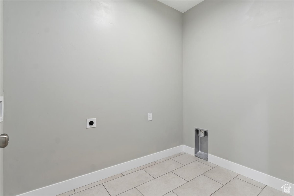 Laundry room featuring light tile patterned floors, hookup for an electric dryer, baseboards, and laundry area