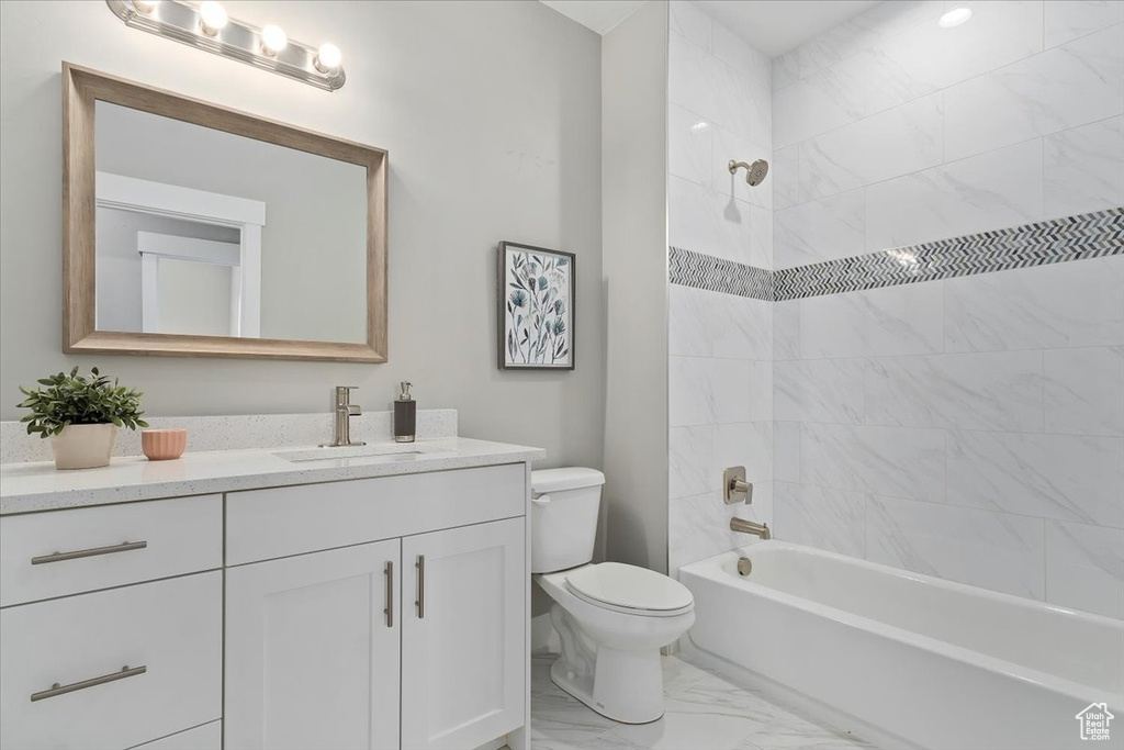 Full bathroom featuring toilet, shower / bath combination, marble finish floor, and vanity