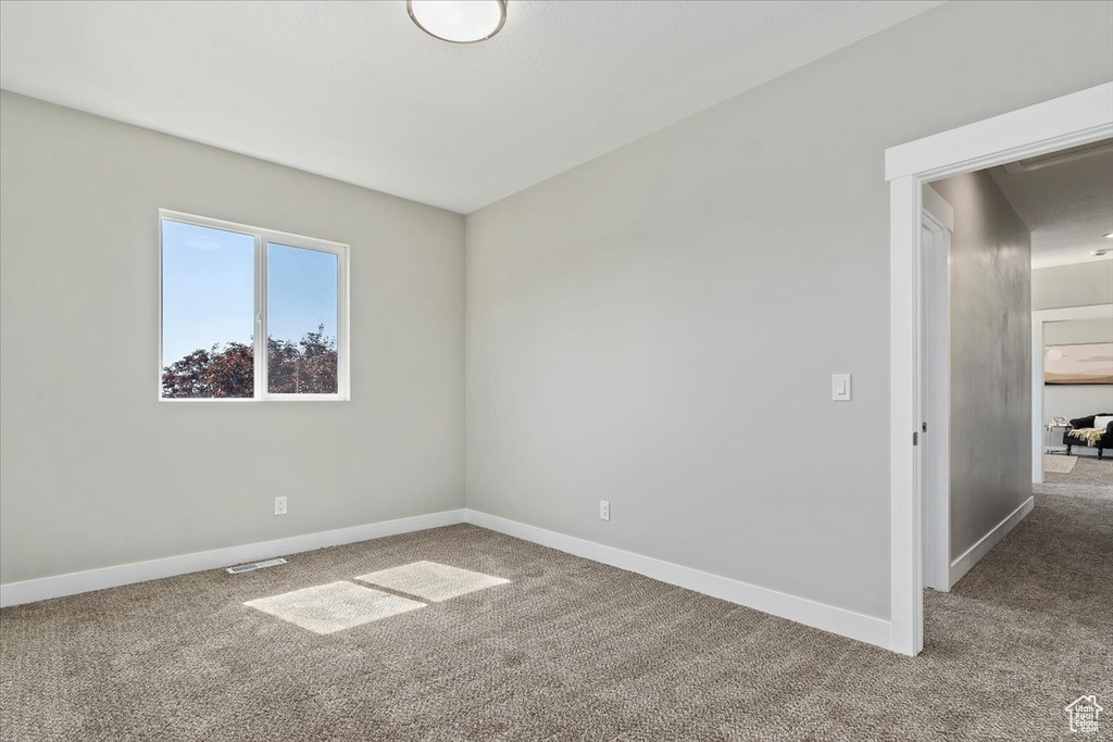 Carpeted spare room with baseboards and visible vents