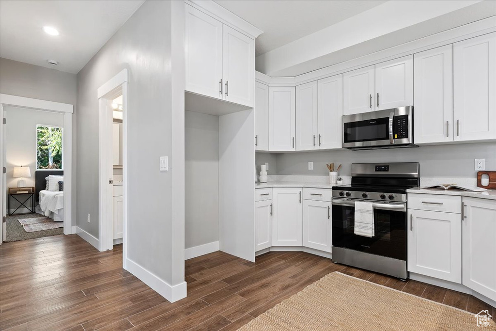 Kitchen with light countertops, appliances with stainless steel finishes, and dark wood finished floors
