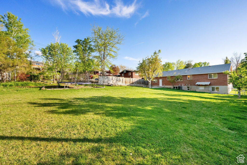 View of yard with fence and a trampoline