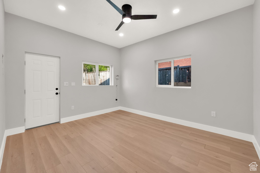 Spare room with a ceiling fan, baseboards, and light wood finished floors