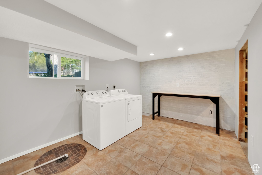 Washroom with laundry area, independent washer and dryer, a fireplace, recessed lighting, and light tile patterned flooring