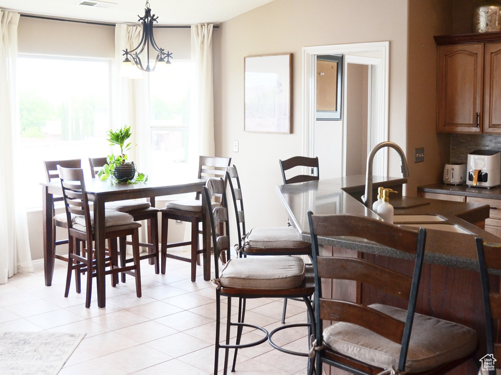Dining area featuring a ceiling fan, lofted ceiling, a textured ceiling, and light tile patterned flooring
