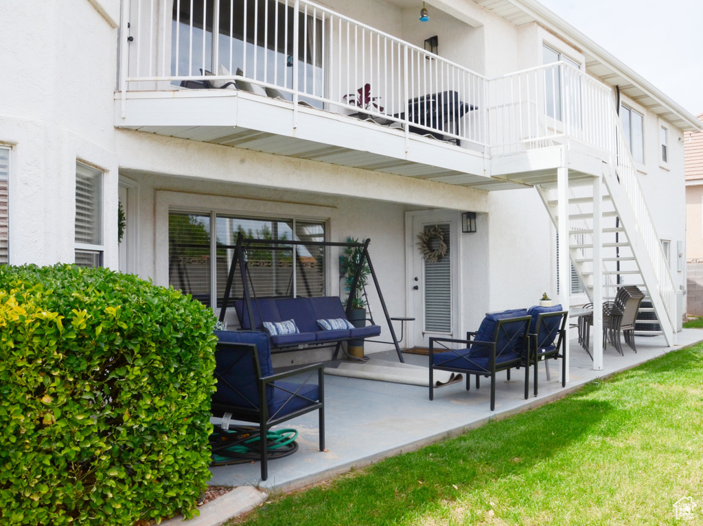 Rear view of house with a trampoline, a patio area, stairway, an outdoor hangout area, and stucco siding