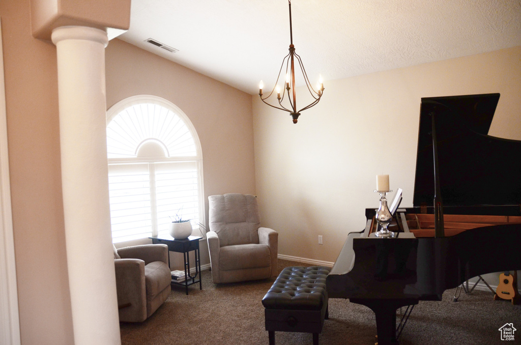 Carpeted living room with vaulted ceiling, ornate columns, a chandelier, and visible vents