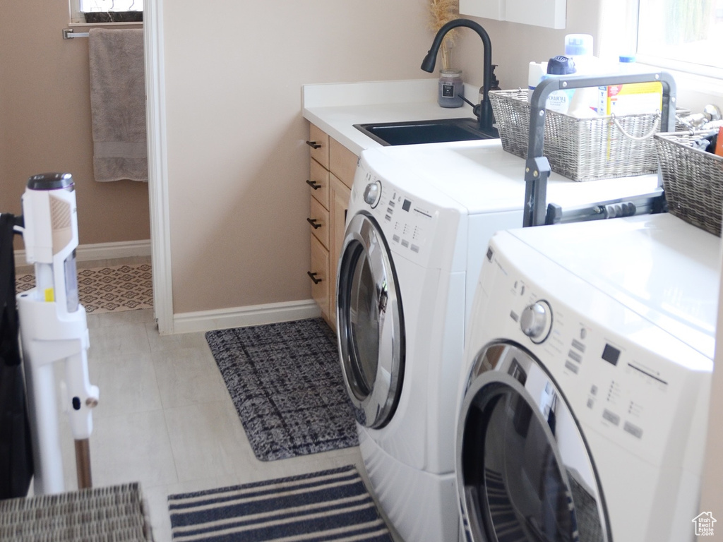 Laundry area featuring laundry area, a sink, plenty of natural light, and washer and clothes dryer