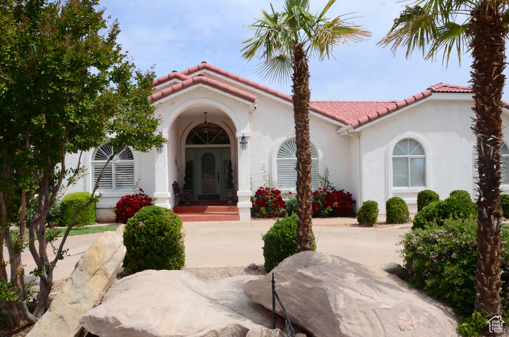 View of front of house featuring stucco siding and a tile roof