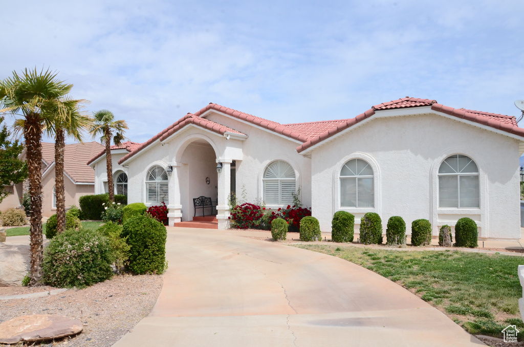 View of front of home with a tiled roof and stucco siding
