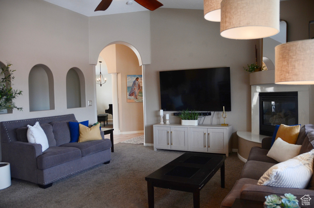 Living area featuring baseboards, carpet flooring, a glass covered fireplace, and ceiling fan