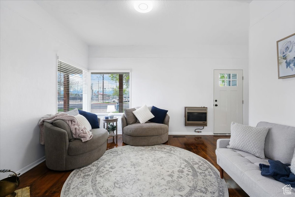 Living room featuring heating unit, a wealth of natural light, and dark wood-style flooring