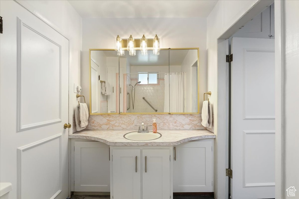 Bathroom with walk in shower, decorative backsplash, and vanity