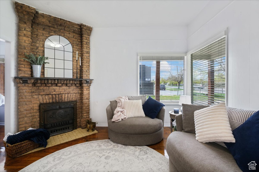 Living area with a brick fireplace and wood finished floors