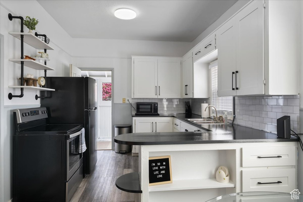 Kitchen with stainless steel electric range oven, open shelves, dark countertops, a sink, and black microwave