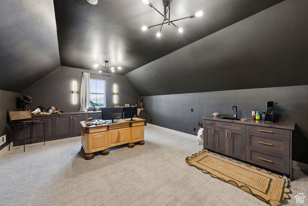 Office space with a notable chandelier, light carpet, a sink, baseboards, and vaulted ceiling