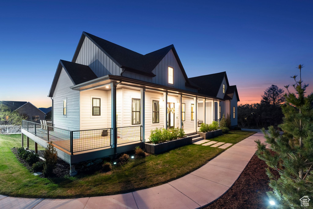 Property exterior at dusk with board and batten siding and a yard
