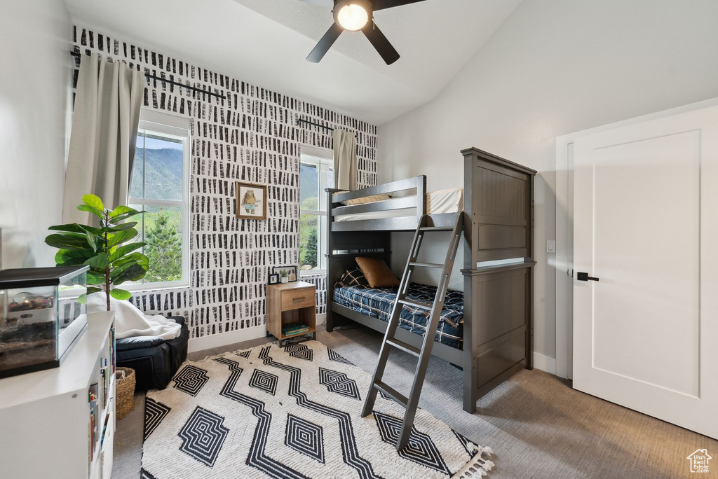 Bedroom with vaulted ceiling, baseboards, and carpet flooring