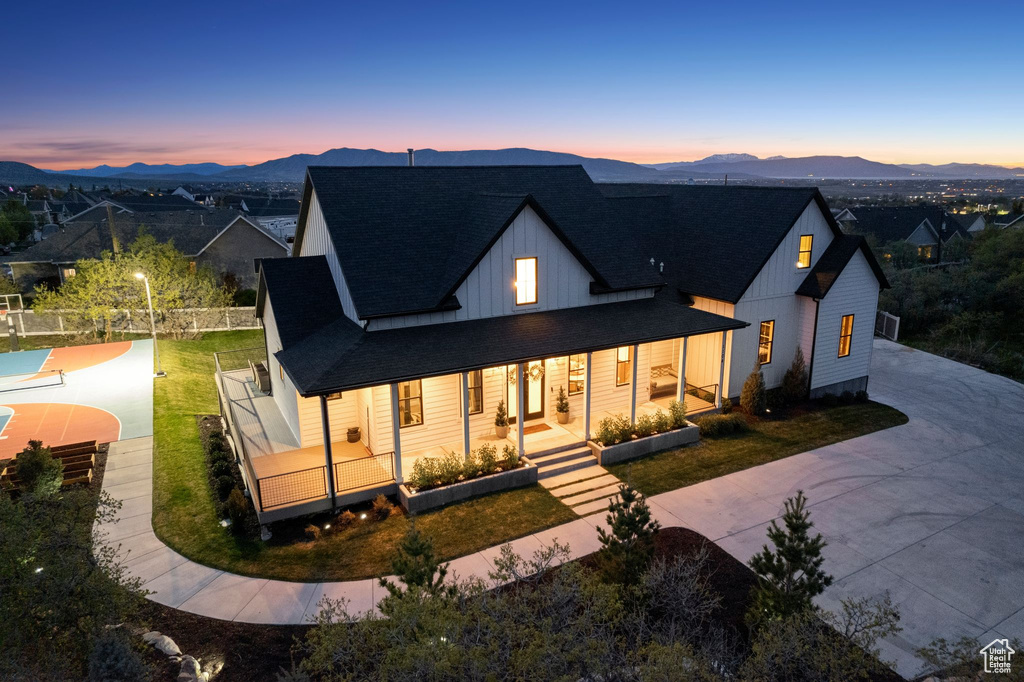 View of front of house featuring board and batten siding, driveway, a mountain view, and roof with shingles