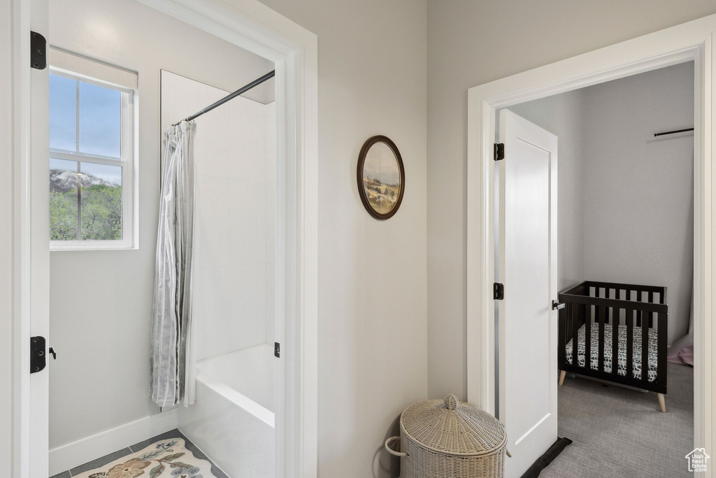 Bathroom with baseboards and shower / bath combination with curtain