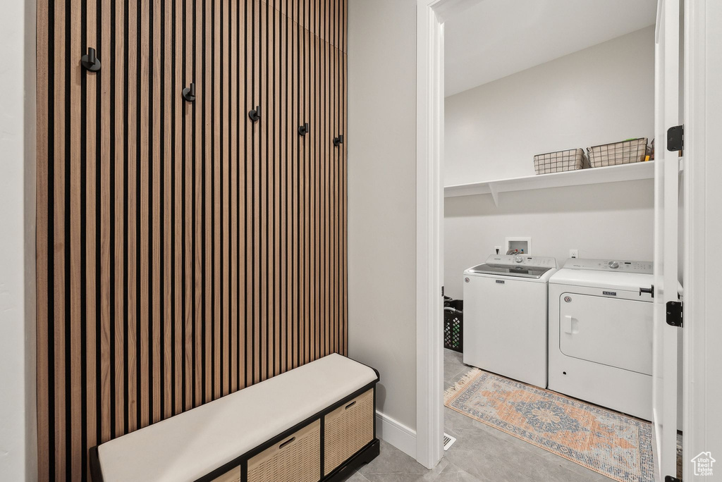 Laundry room featuring separate washer and dryer, laundry area, and light tile patterned flooring