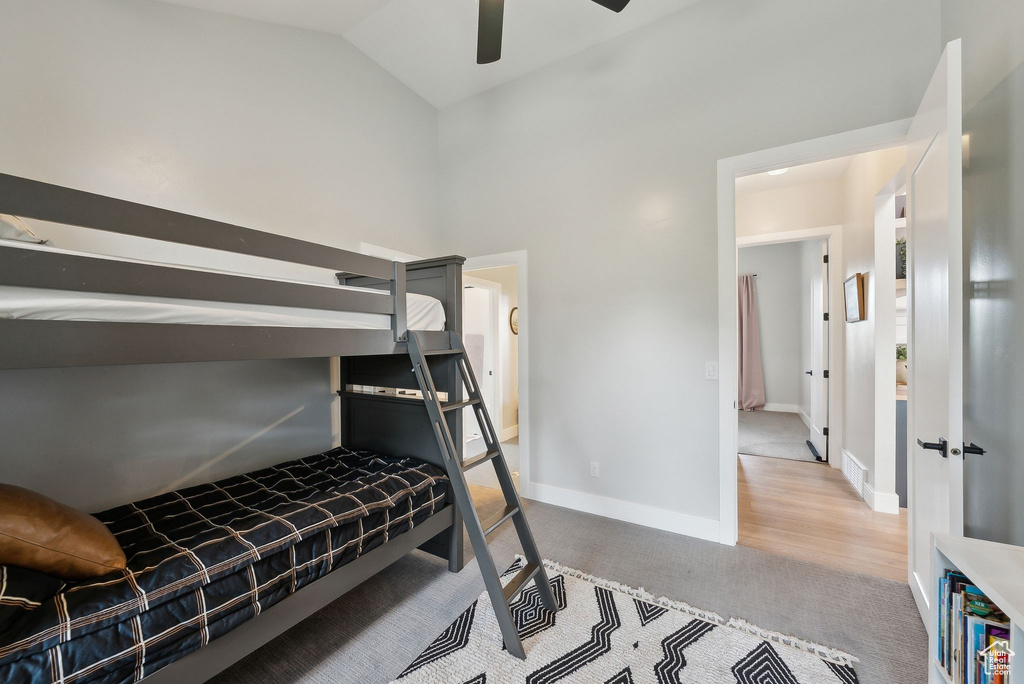 Bedroom featuring ceiling fan, visible vents, baseboards, high vaulted ceiling, and carpet