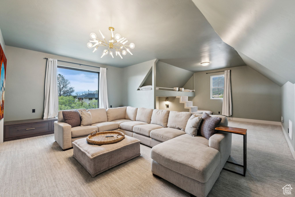 Carpeted living area with an inviting chandelier and vaulted ceiling