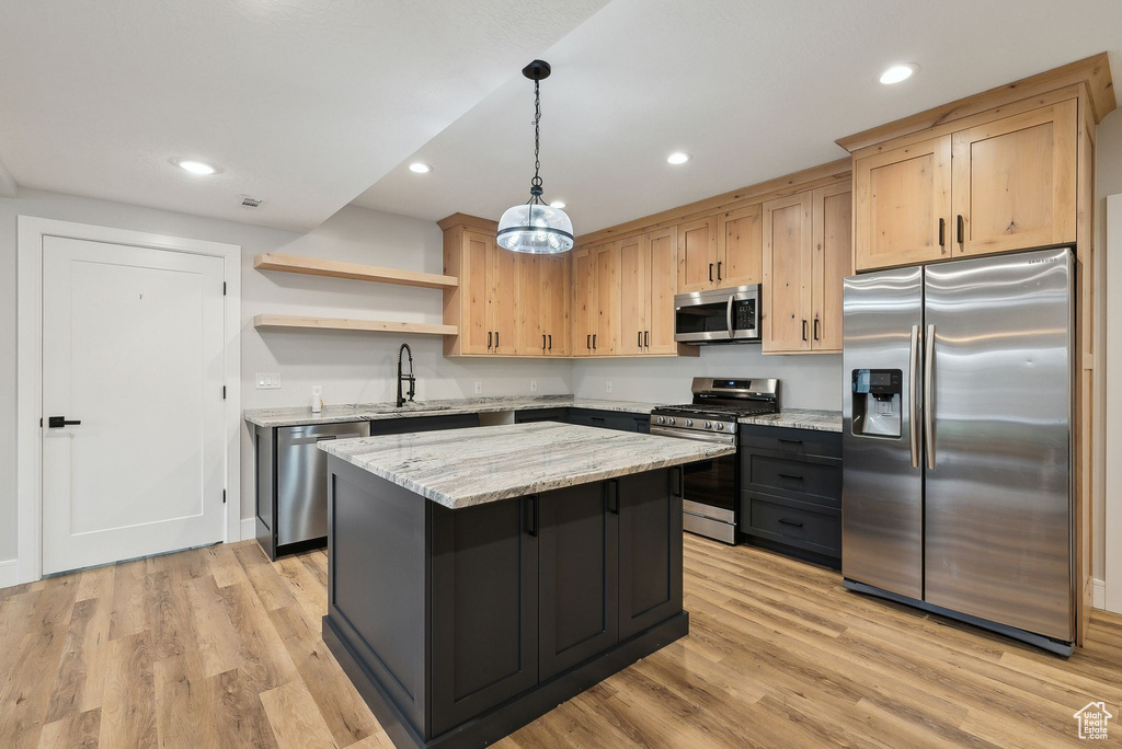 Kitchen with light brown cabinetry, stainless steel appliances, open shelves, and light wood finished floors