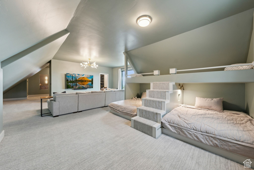 Bedroom with carpet flooring, lofted ceiling, and a notable chandelier