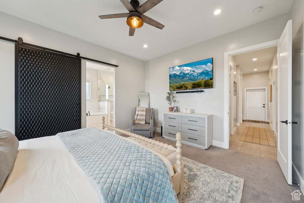 Bedroom with light carpet, recessed lighting, and a barn door