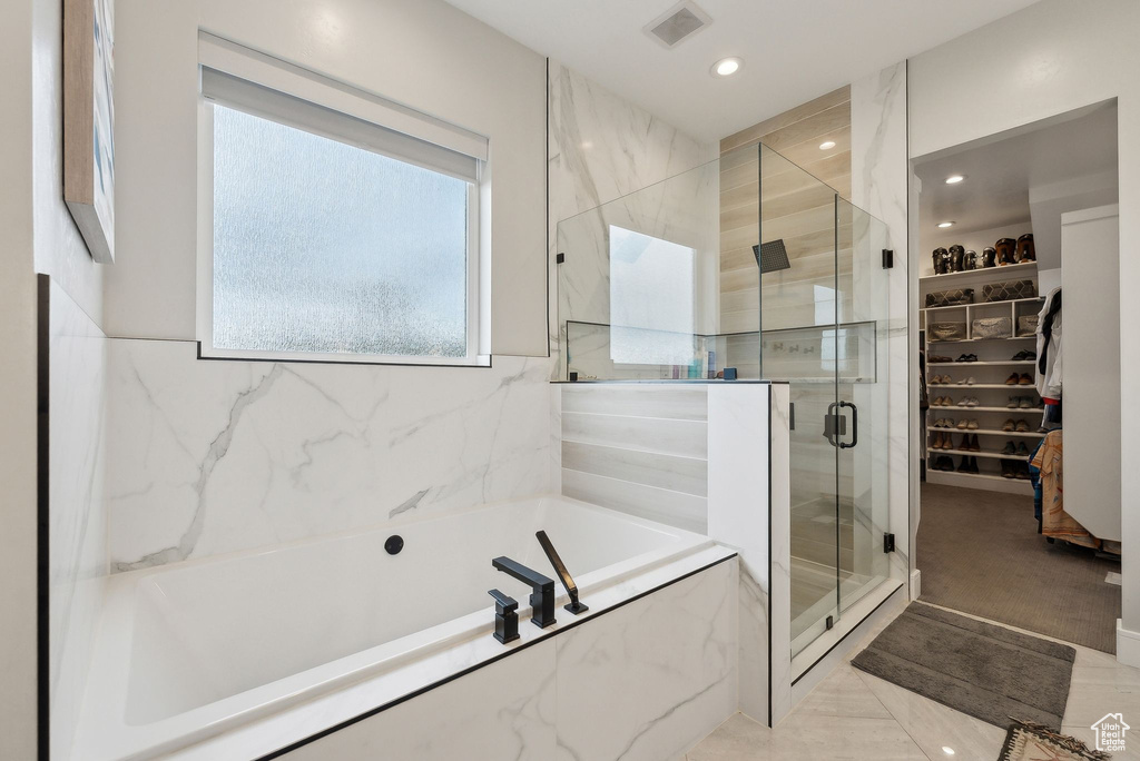 Full bathroom with visible vents, a walk in closet, recessed lighting, a bath, and a stall shower