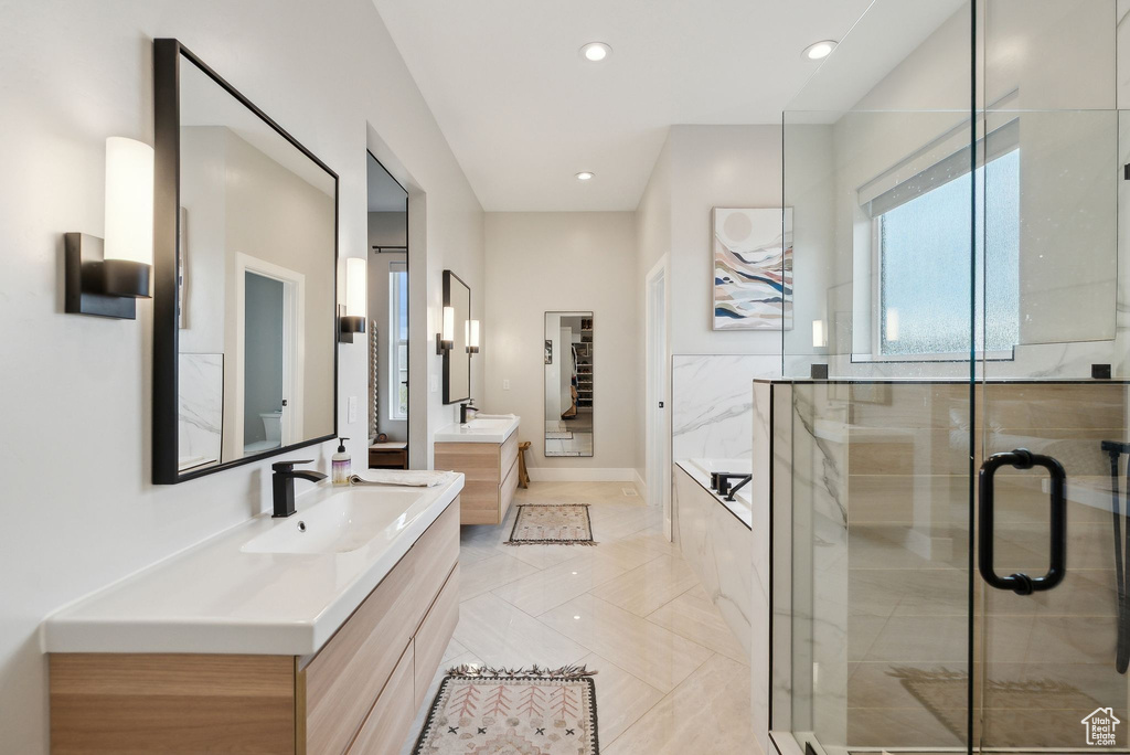 Bathroom featuring a sink, recessed lighting, two vanities, a garden tub, and a stall shower