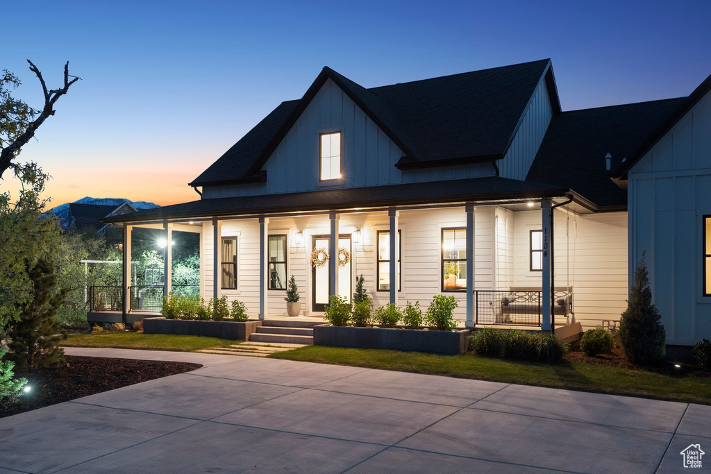 Rear view of property featuring board and batten siding and a porch