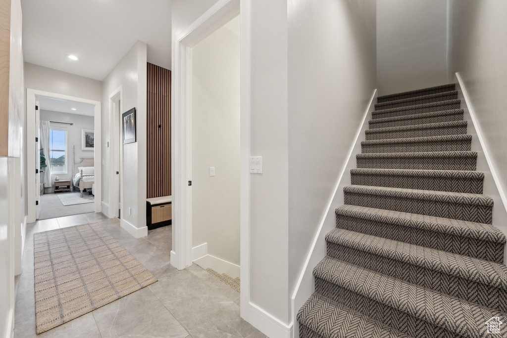 Stairway featuring tile patterned floors and recessed lighting