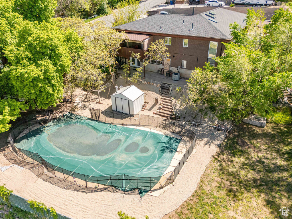 View of swimming pool featuring an outdoor structure and fence